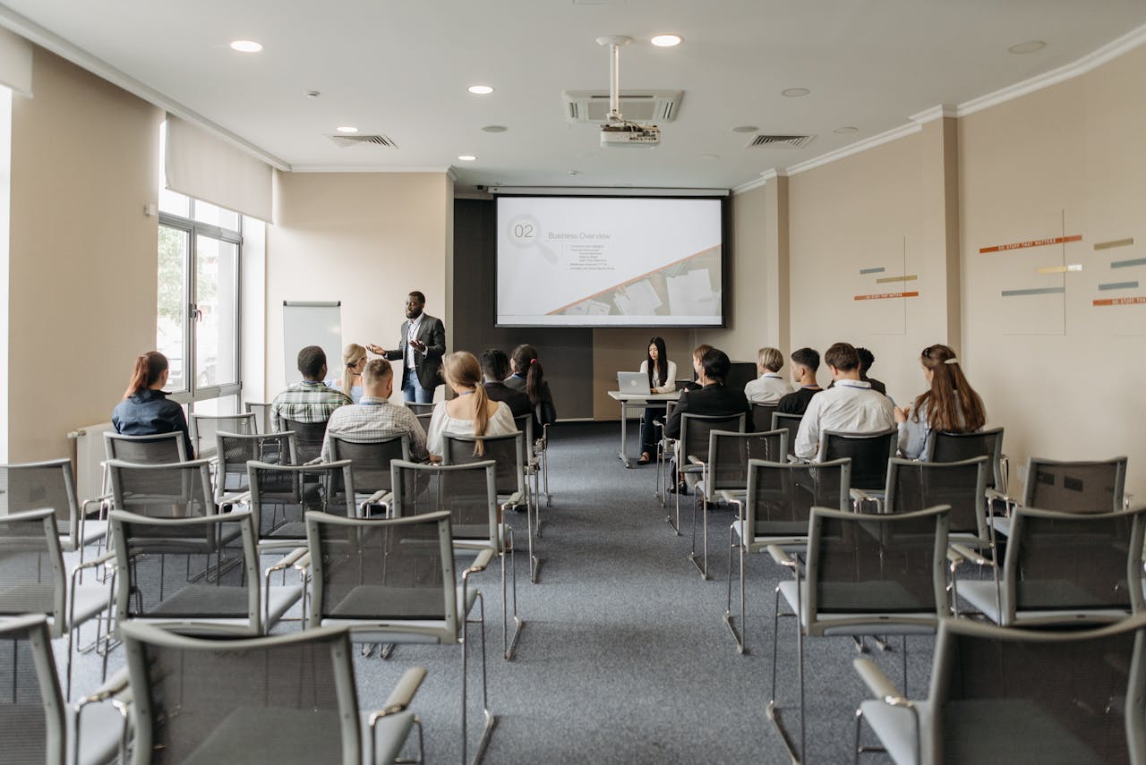 A group attending a business presentation in a modern conference room with projector.